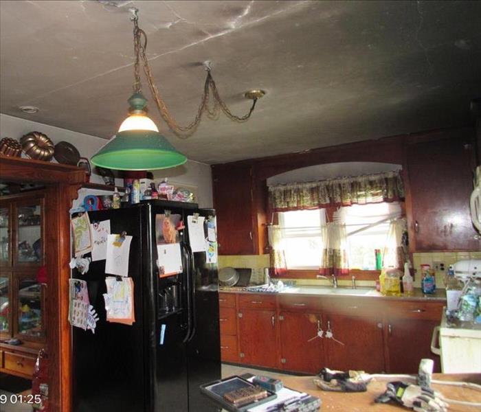 A kitchen with dark walls due to soot. 