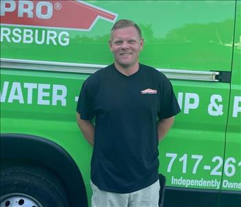 A man IN front of a green SERVPRO van 